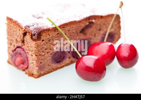 Kirschkuchen, Stück Kuchen, Puderzucker, Kirschen, Kuchen, Schokoladenkuchen, Stück, Obst, Obstkuchen, weiß, Hintergrund, Kirsche, voll, echt, real, fru Stockfoto