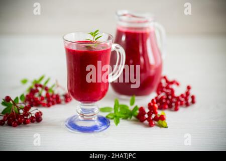 Frisch gepresster dicker natürlicher Saft mit Fruchtfleisch aus reifen roten Viburnum in einer Karaffe Stockfoto
