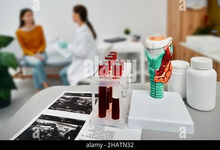 Diagnostik von Schilddrüsenerkrankungen, Hypothyreose oder Hyperthyreose. Endokrinologe, der eine Patientin mit endokrinologischer Erkrankung bei einem Arzt konsultiert Stockfoto