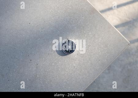 Runde stilvolle Kompass auf Beton Hintergrund, Suchrichtung mit Kompass in Sommerbergen, Sicht. Stockfoto