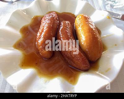 Eine Schüssel gebratene Bananen in Honig zum Nachtisch. Dessert mit Spezialitäten der Seychellen. Stockfoto