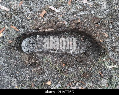 Fußabdruck der Männer Stiefel im Schlamm Winter Nahaufnahme Draufsicht Hintergrund Stockfoto