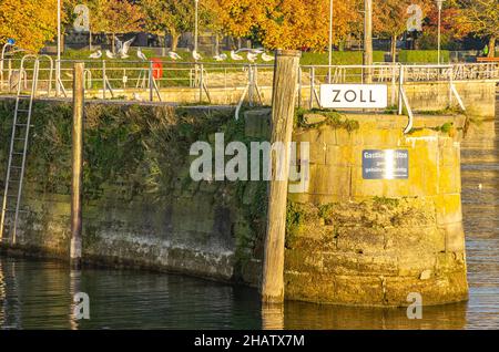 Schild mit der Bezeichnung ZOLL (für ZOLL in Englisch) an einer Anlegestelle auf der Anlegestelle im Hafen von Meersburg, Baden-Württemberg, Deutschland. Stockfoto