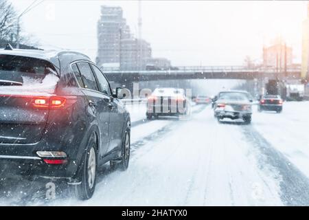 Landschaftlich schöne Aussicht schneebedeckte Stadt Autobahn rutschige Straße fahren Autos bewegen schnelle Geschwindigkeit Bewegung. Schneefall Gefahr Schneesturm Schlechtes Winterwetter. Stadt Stockfoto