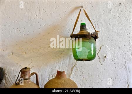 Tonkrüge und zerbrochene Weinflasche vor der weißen Wand, Andalusien, Spanien Stockfoto