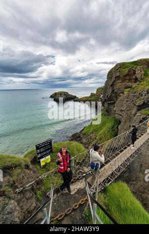 Schmale Hängebrücke für Fußgänger an der felsigen Küste, unbewohnte Insel Carrick-a-Rede, County Antrim, Nordirland, Großbritannien Stockfoto