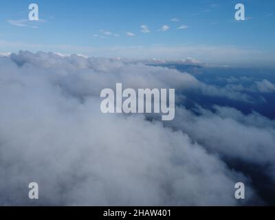 Hoch über dem dichten Nebel, wie ein wunderschönes Wolkenmeer bei Sonnenaufgang. Die Sonne geht über dem endlosen Wolkenmeer bis zum Horizont auf. Atemberaubende Natur Stockfoto