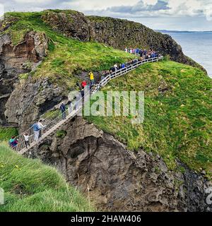 Schmale Hängebrücke für Fußgänger an der felsigen Küste, unbewohnte Insel Carrick-a-Rede, County Antrim, Nordirland, Großbritannien Stockfoto