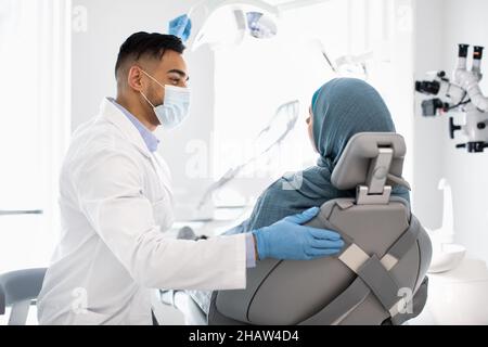 Zahnarzttermin. Naher Osten Stomatologe Arzt Mit Überprüfung Mit Muslimischer Dame Stockfoto