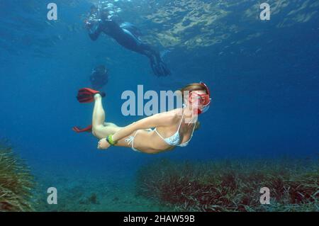 Schnorchler taucht hinunter schwimmt über Seegras (Posidonia oceanica), im Hintergrund Schnorchler auf der Wasseroberfläche, Mittelmeer Stockfoto