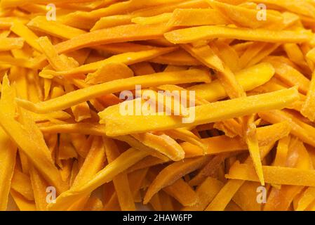 Trockene, leckere Mangoscheiben als Hintergrund. Draufsicht. Stockfoto