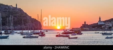 Sonnenuntergang über dem Meer, Leuchttürme rechts und links, Boote davor, Hafen Port de Soller, Mallorca, Spanien Stockfoto