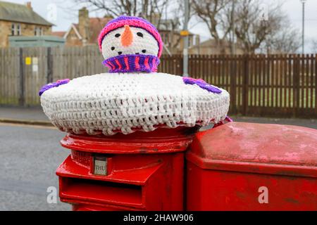 Troon, Großbritannien. 15th Dez 2021. Über Nacht wurden gestrickte Winterdekorationen auf lokale Briefkästen gelegt, die der festlichen Jahreszeit Beifall und Humor beifügten. Die anonymen Stricker oder Stricker haben die Einheimischen zum Lächeln gebracht, als sie vorbei gehen oder anhalten, um die dekorierten Briefkästen zu benutzen. Kredit: Findlay/Alamy Live Nachrichten Stockfoto