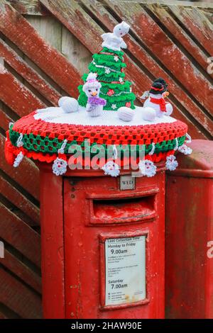 Troon, Großbritannien. 15th Dez 2021. Über Nacht wurden gestrickte Winterdekorationen auf lokale Briefkästen gelegt, die der festlichen Jahreszeit Beifall und Humor beifügten. Die anonymen Stricker oder Stricker haben die Einheimischen zum Lächeln gebracht, als sie vorbei gehen oder anhalten, um die dekorierten Briefkästen zu benutzen. Kredit: Findlay/Alamy Live Nachrichten Stockfoto