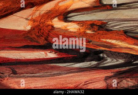 Drohnenschuss, bunte Fischernetze, die im Hafen, Vila Franca do Campo, Sao Miguel Island, Azoren, Portugal, zum Trocknen ausgelegt sind Stockfoto