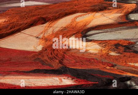 Drohnenschuss, bunte Fischernetze, die im Hafen, Vila Franca do Campo, Sao Miguel Island, Azoren, Portugal, zum Trocknen ausgelegt sind Stockfoto