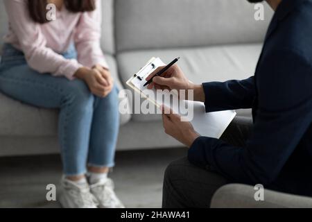 Professionelles psychologisches Hilfekonzept. Nicht erkennbare weibliche Patientin, die im Büro mit einer Psychotherapeutin spricht Stockfoto