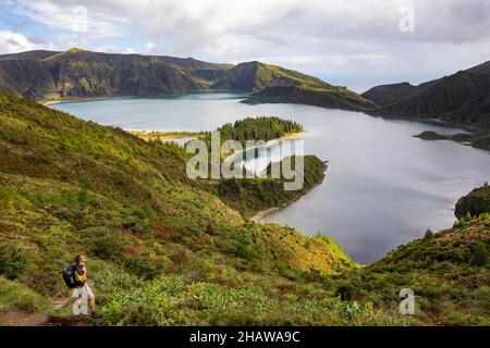 Wanderer am Krater mit Blick auf den Krater-See Lagoa do Fogo, Sao Miguel Island, Azoren, Portugal Stockfoto