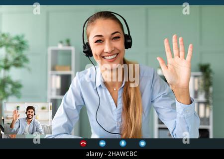 Glückliche Lehrerin, die Kopfhörer trägt, während einer Videokonferenz, winkt und lächelt zur Webcam, Screenshot Stockfoto