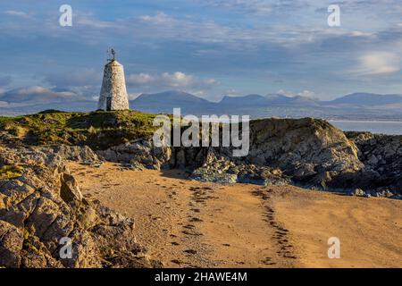 TWR Bach Leuchtturm auf Ynys Llanddwyn mit den Snowdonia Bergen im Hintergrund, Isle of Anglesey, Nordwales Stockfoto