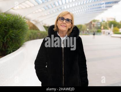 Ältere stilvolle Frau in elegantem schwarzen Mantel in der Stadt. Stockfoto