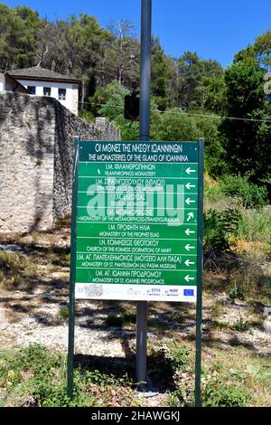 Ioannina, Griechenland - 27. Juni 2021: Richttafel für die Klöster in griechischer und lateinischer Schrift auf der winzigen Insel im Pamvotis-See Stockfoto