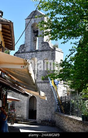 Ioannina, Griechenland - 27. Juni 2021: Unbekannte Frau und Souvenirladen in der engen Straße vor der byzantinischen Kirche von Theotokou auf der kleinen Stockfoto
