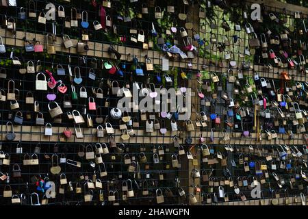 Liebe Vorhängeschlösser auf einem Holz-/Drahtrahmen, um die Brücke vor Schäden durch das Gewicht zu schützen. Stockfoto