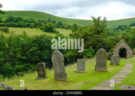 St. Issui's Church Friedhof und bedecktes Tor in einer hügeligen Landschaft, Partrishow, Powys, Wales, Großbritannien Stockfoto