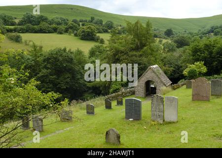 St. Issui's Church Friedhof und bedecktes Tor in einer hügeligen Landschaft, Partrishow, Powys, Wales, Großbritannien Stockfoto