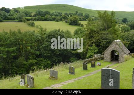 St. Issui's Church Friedhof und bedecktes Tor in einer hügeligen Landschaft, Partrishow, Powys, Wales, Großbritannien Stockfoto