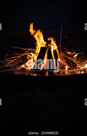 Die vertikale Aufnahme des Lagerfeuers und des Sumpfes auf dem hölzernen Stock Stockfoto