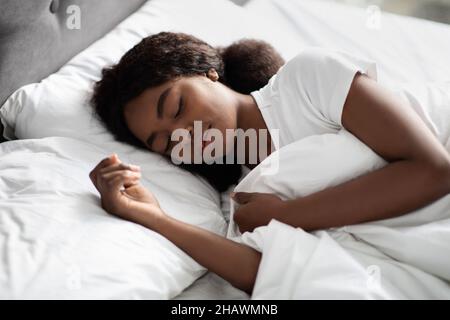 Nahaufnahme Porträt einer jungen schwarzen Frau, die im Bett schläft Stockfoto