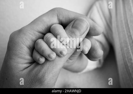 Das neugeborene Baby hat nach der Geburt einen festen Griff am Finger der Eltern. Stockfoto