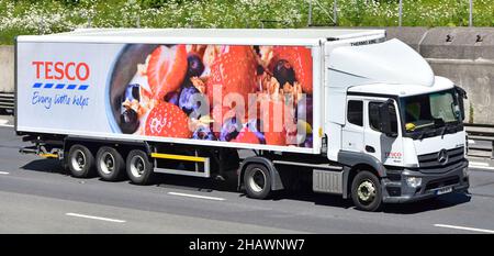 Tesco Supermarkt Einzelhandel Geschäft Anhänger Seite Vorderansicht Lebensmittel Werbung Grafik weiß Mercedes lkw LKW LKW-LKW fahren auf englischer UK Autobahn Straße Stockfoto