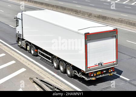 Weiß unmarkiert sauberer lkw-Lieferkettentransport LKW-Sattelanhänger in Luftaufnahme und Rückansicht auf englischer britischer Autobahnstraße Stockfoto
