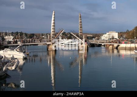 Eine Fußgängerbrücke mit doppelter Bascule über den Eingang zum Innendock im Hafen von Torquay, Süd-Devon. Stockfoto