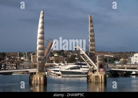 Eine Fußgängerbrücke mit doppelter Bascule über den Eingang zum Innendock im Hafen von Torquay, Süd-Devon. Stockfoto