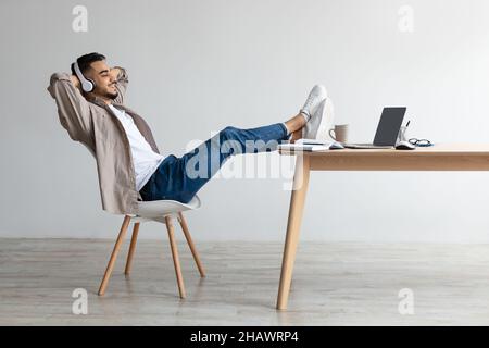 Asiatischer Mann, der mit Kopfhörern Musik hört Stockfoto