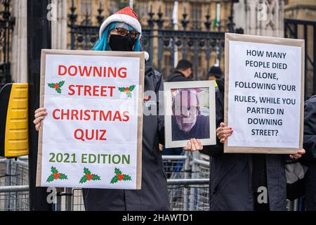 WESTMINSTER LONDON, GROSSBRITANNIEN. 15. Dezember 2021. Eine trauerte Frau vor dem Parlament hält das Bild eines Familienmitglieds, das an Covid-19 gestorben ist. Premierminister Boris Johnson hat Baroness Heather Hallett zum Vorsitzenden der öffentlichen Untersuchung über den Umgang der Regierung mit der Pandemie Covid-19 ernannt, die im Frühjahr 2022 beginnen wird. Kredit: amer ghazzal/Alamy Live Nachrichten Stockfoto