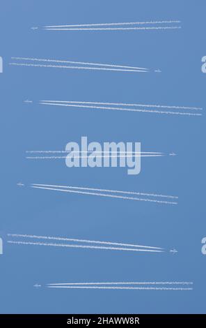 Flugzeuge mit zwei Triebwerken, die über blau bewölktem Himmel fahren. Konzept des überlasteten Luftraums Stockfoto