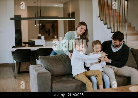 Niedliche Geschwister kämpfen zu Hause um die Fernbedienung des Fernsehers Stockfoto