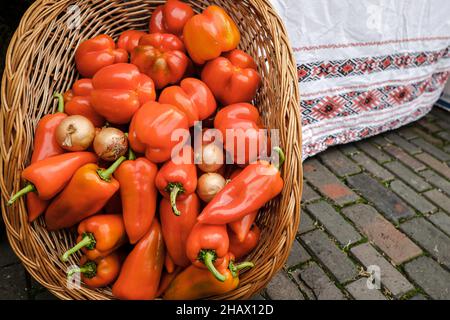 Bild mit geringer Schärfentiefe (selektiver Fokus) mit einem Korb gefüllt mit frischen Paprika aus biologischem Anbau zum Verkauf auf einem Markt im Freien in Bukarest, Romani Stockfoto