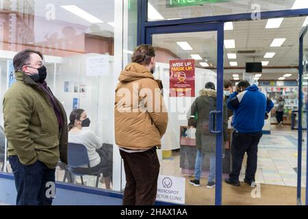 Am Eingang des Impfzentrums covid-19 stehen Menschen Schlange, die auch Flugtaugungstests für Reisende in Lewisham London, Großbritannien, durchführen Stockfoto