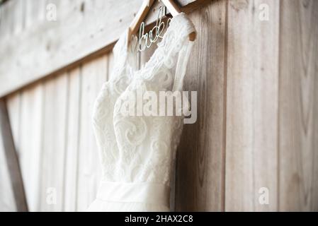 Schöne weiße Hochzeitskleid hängen von Scheune Tür Stockfoto