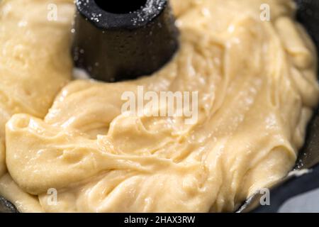 Zitronenpfaumteig in einer gebrannten Backform, fertig zum Backen. Stockfoto