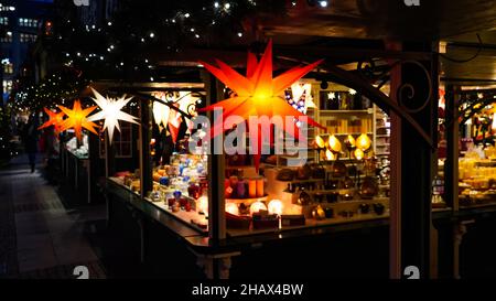 Beleuchteter Weihnachtsmarkt-Kiosk mit vielen glänzenden Dekorationsartikeln Stockfoto