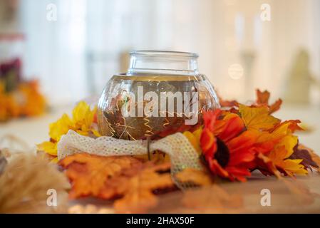 Herbst dekorative Kerzenhalter Mittelstück mit Herbstlaub um ihn herum Stockfoto