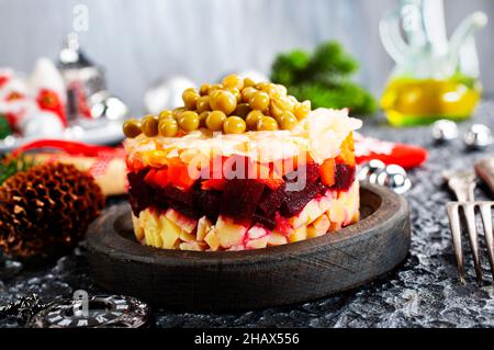 Salat aus Rüben, Karotten, Kartoffeln, Zwiebeln und grünen Erbsen. Traditioneller russischer Rote-Beete-Salat. Vegetarischer Gemüsesalat. Stockfoto