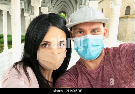 Nahaufnahme Selfie von glücklichen multirassischen Paaren Gesichter mit Masken auf einem öffentlichen Platz. Natürliches Hintergrundbild. Stockfoto